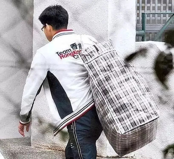 ▲背着编织袋搬家的霍启刚