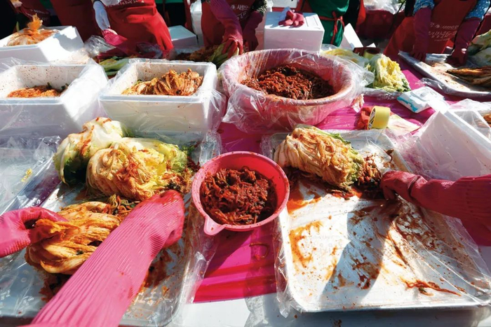 ▲贵府图：志愿者们在泡菜节上制作泡菜。图/新华社