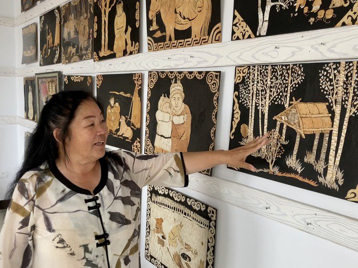 　　鄂伦春族民间画家关桃芳在介绍她的桦树皮镂空画作品。新华社记者 金地 摄