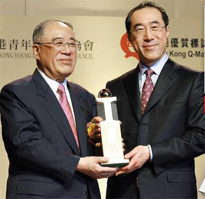 ▲2008年底，唐翔千（左）从儿子唐英年手中接过“杰出工业家”奖杯，成为一时佳话