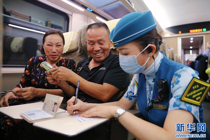 资料图 中老铁路列车长赵莹静，协助跨境旅客填写相关信息。杨紫轩 摄
