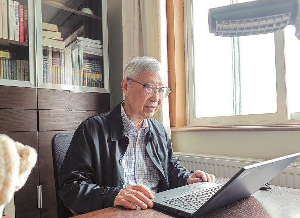 翻阅国内外城市设计案例是卢济威热衷的乐趣  本报记者  陶磊  摄