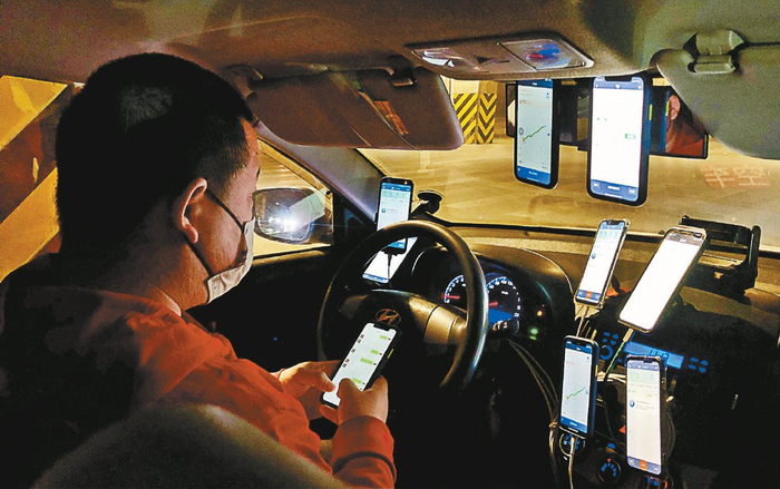 一位出租车司机在车内用九台手机抢单
