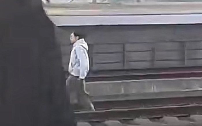 一女子在火车轨说念上行走。网传视频截图