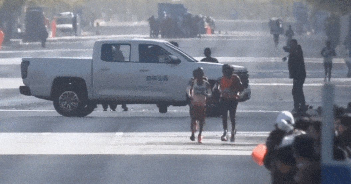 大连马拉松赛事主办方的皮卡车横在了一位专业跑手面前。图源：网页截图