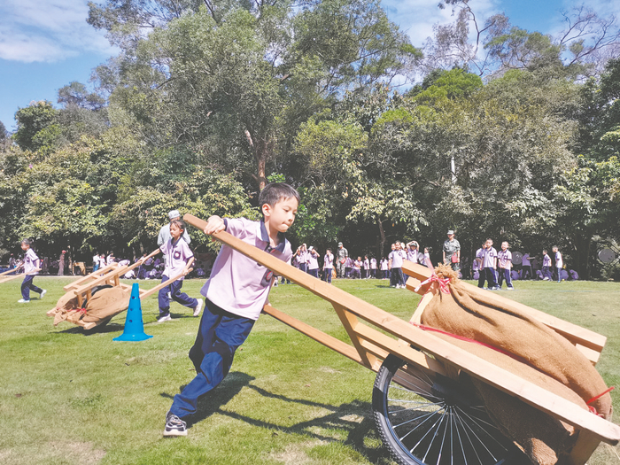     南宁市五一中路学校秋季学期研学活动中，学生进行“独轮车运粮”户外拓展项目。 （学校供图）