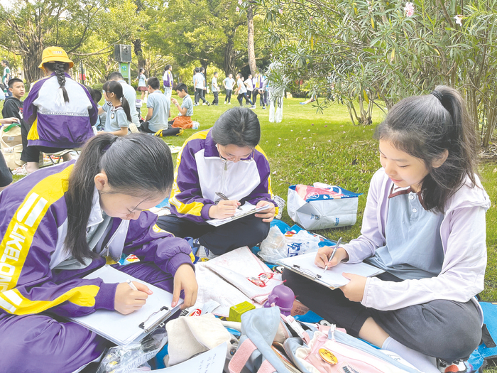     南宁市百花岭路小学学生用纸和笔记录南湖美景。（学校供图）