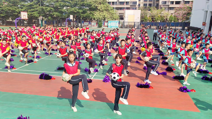     ▶南宁市桃花源小学“阳光体育 活力绽放”课间操评比活动中，学生展示校本足球操。 （王熙亮 摄）
