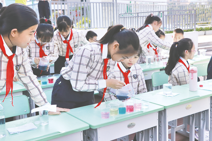     ▲南宁市逸夫小学贤宾校区科技节上，学生探索颜色变化的奥秘。 （学校供图）