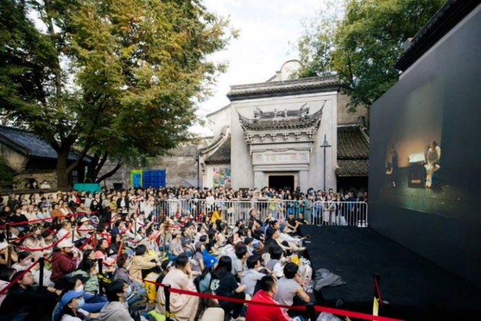 蚌湾剧场门口席地而坐看青年竞演直播的观众