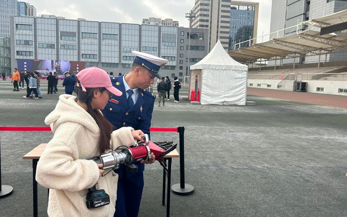 学生在消防员的指导下尝试使用液压钳。  新京报记者 彭镜陶 摄