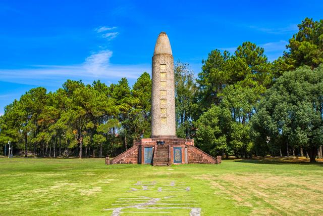 炮弹造型的红军烈士纪念塔耸立在空旷的草坪中,塔身四周镶嵌着无数粒
