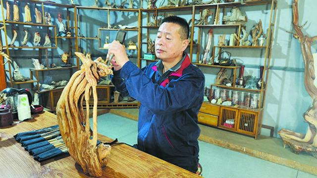 一截枯木,经过根雕艺人的精雕细刻,耐心打磨后,就能重新焕发出新的