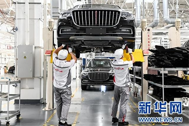 工人在位于吉林长春的一汽红旗工厂总装车间内装配车辆。