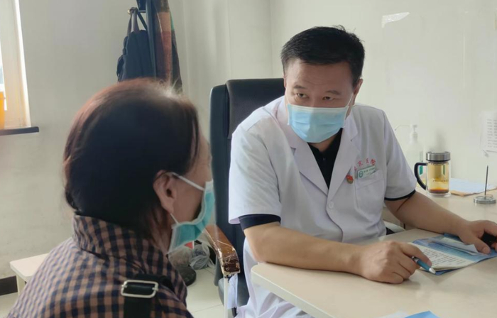 ￼朱立国教授（右）出诊。图据健康时报