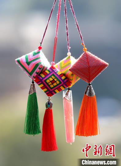 图为参加研学活动的大学生在学习侗族吉祥花制作技艺.