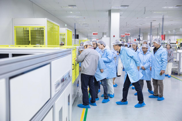 在安徽赛拉弗能源有限公司生产车间，媒体记者、网络大V们认真聆听企业负责人的介绍。 澎湃新闻记者 罗振宇 图