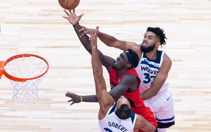 戈贝尔（下）和唐斯（上）包夹防守猛龙球员西亚卡姆。  图/新华社