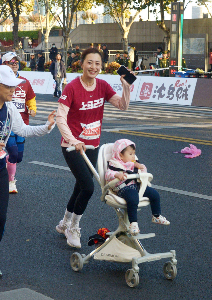 推着孩子的跑友。