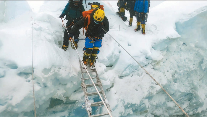 张洪必须跨过冰裂缝上的横梯，横梯下面是一眼望不到底的幽暗深渊。