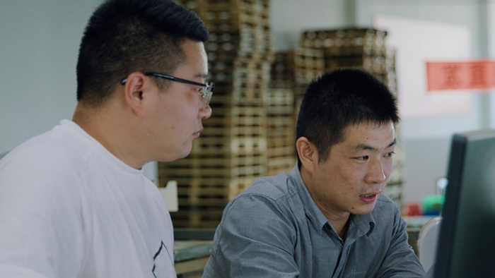 ▲加工厂厂长饶愿恒正在查看冰糖橙的检测数据