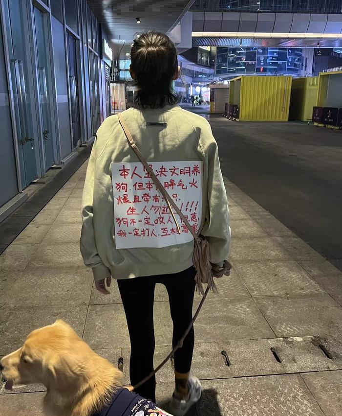 崇州罗威纳犬撕咬女童事件发生后,柚柚在遛狗时用宣言抗议周围东说念主对大型犬的敌意。受访者供图
