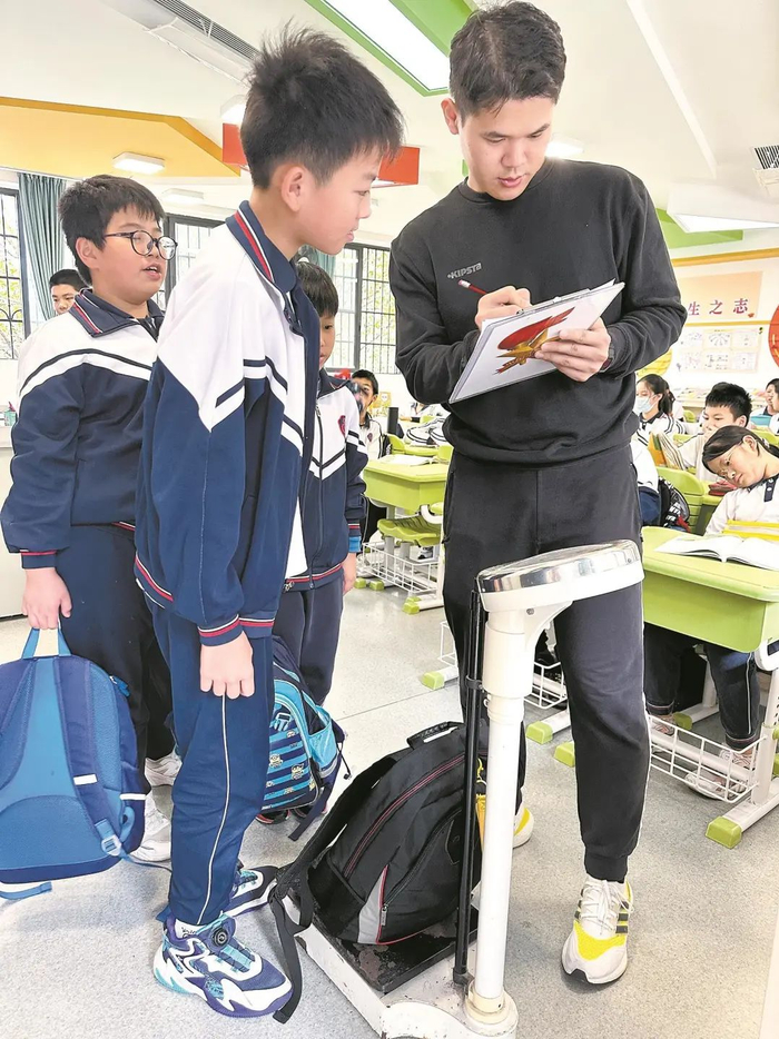 广州市海珠区实验小学行政老师抽检学生书包重量 学校供图