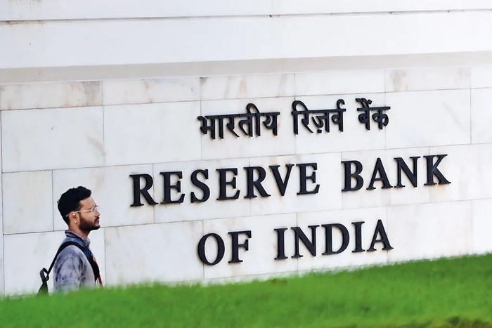 2022 年 8 月 5 日，在印度孟买，一名男子从印度央行标志前走过。 新华社/法新
