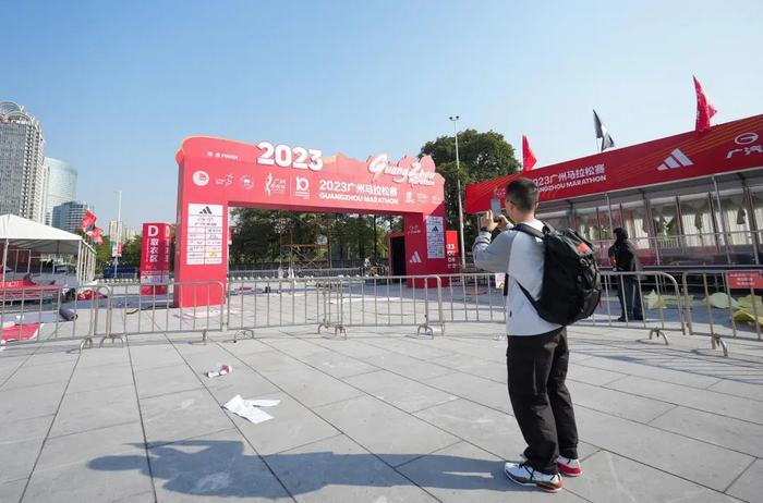 花城广场与海心沙交界处，市民游客拍摄已经搭建好的广马全马终点（梁怿韬 摄）