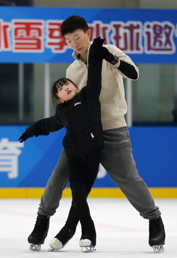 1月15日，教练员杨曦（右）在冰上训练中为8岁的小学员郑诗琪指导花样滑冰技术动作。 新华社记者 张晨 摄