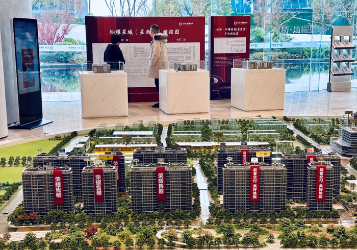 （在虹桥灿耀星城项目营销中心，两位购房者正在查看户型图。本报资料室/图）