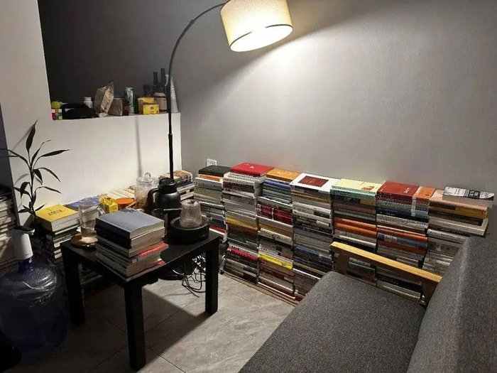 ▲ 天胡搬进新家后，码在墙边的四百多本书。