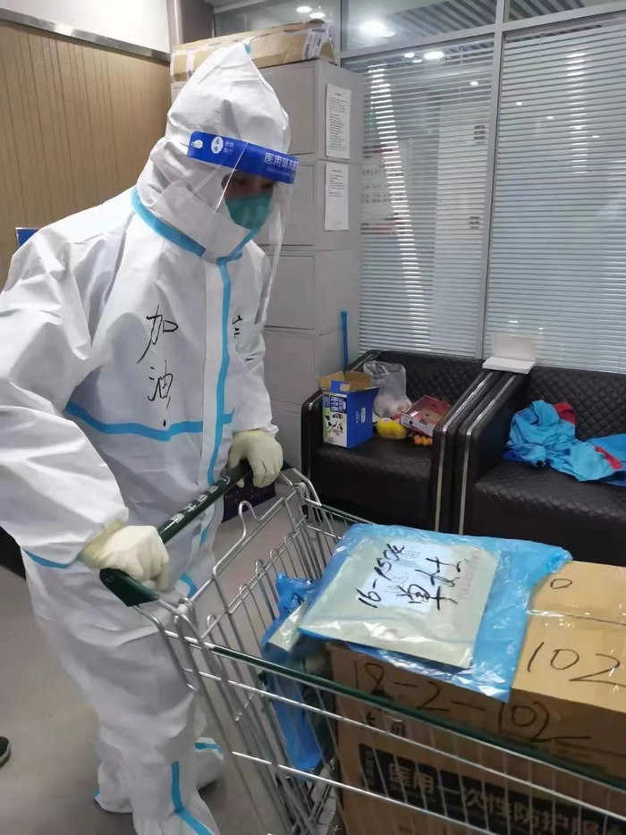 穿着防护服的宗呈裕正帮忙转运物资。受访者供图