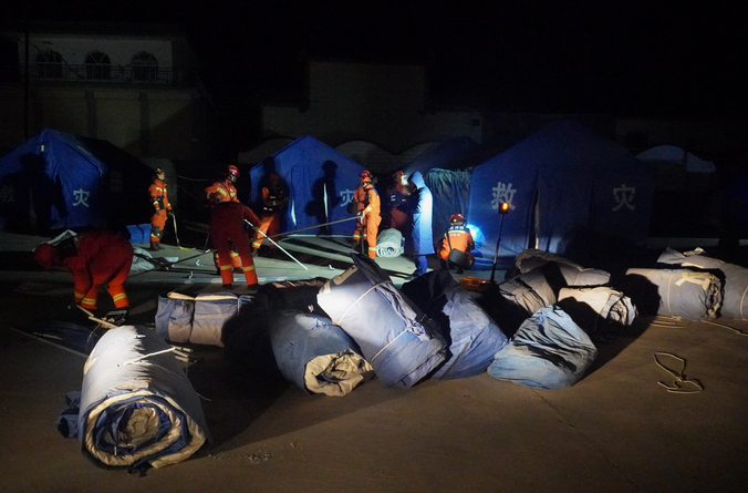 12月19日，在甘肃省临夏回族自治州积石山保安族东乡族撒拉族自治县大河家镇大河村，消防人员搭建救灾帐篷。新华社 图