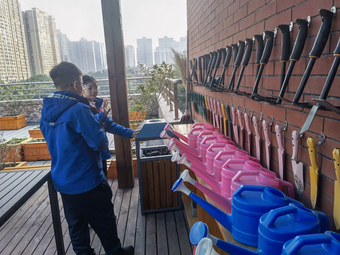 五年级一班的杜佳萱和王太子，对农场的各种农具如数家珍。新京报记者 周怀宗 摄