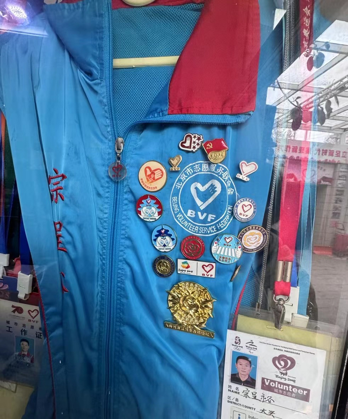 宗呈裕的志愿者马甲上别满了徽章。 新京报记者 熊丽欣 摄