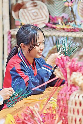 在广西岑溪市南渡中心小学，小学生在练习竹芒编织技艺。新华社发