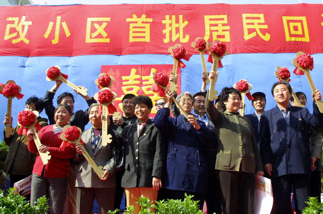 2002年4月，金鱼池首批危改居民高举象征幸福的金钥匙，喜迎回迁。孙戉摄 