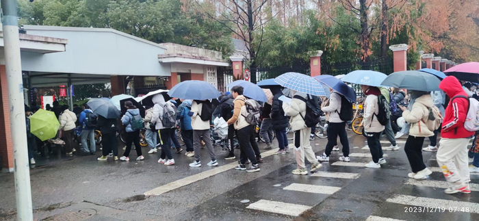 12月19日早上，复旦大学邯郸校区国权路校门口，学生排队刷卡入校。受访者 供图