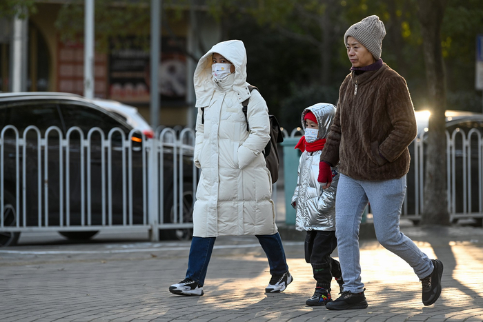 2023年12月21日，上海，小朋友穿着羽绒服，戴着围巾和口罩，裹得严严实实去上学。