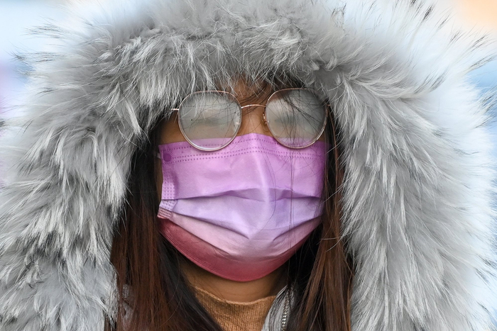 2023年12月21日，上海，市民穿着羽绒服，戴着口罩出行。