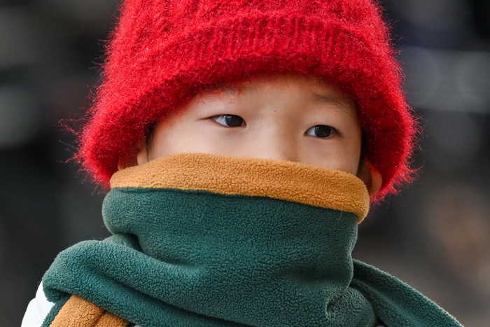 2023年12月21日，上海，小朋友穿着羽绒服，戴着围巾，裹得严严实实去上学。