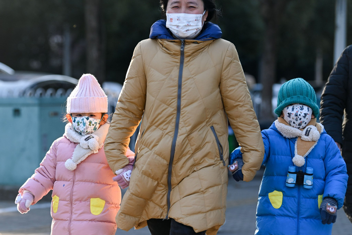 2023年12月21日，上海，小朋友穿着羽绒服，戴着围巾和口罩，裹得严严实实去上学。