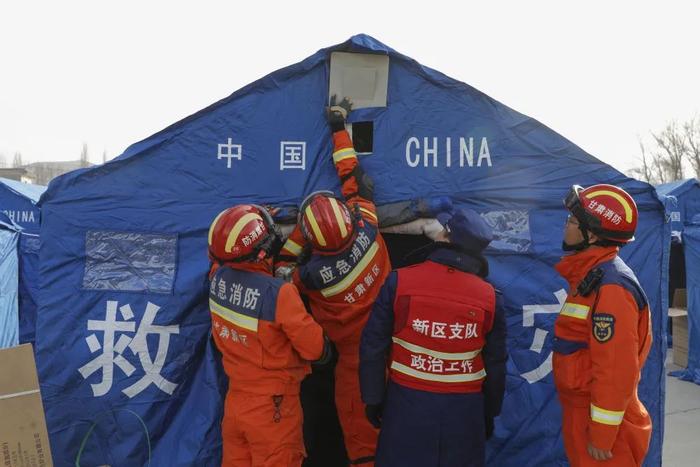 12月19日,在甘肃临夏积石山县大河家镇大河村安置点,消防东说念主员在装置取暖缔造。新华社记者 方欣 摄