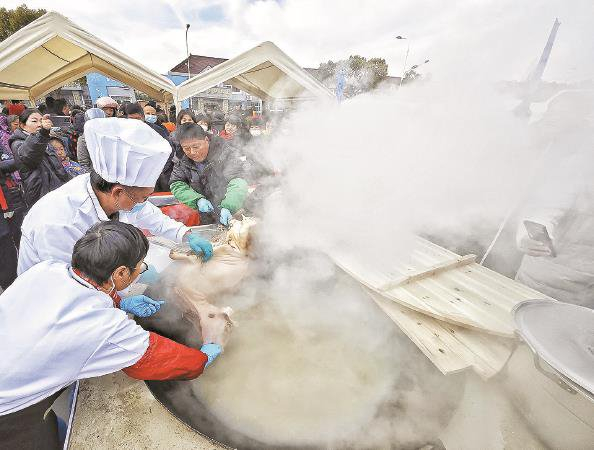             热气腾腾的整羊熬汤，吸引不少村民前来排队品尝    本报记者  陶磊  摄          