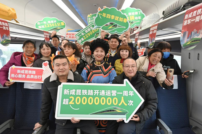 2023年12月25日，在新成昆铁路C46次列车上旅客共庆“新成昆铁路开通一周年”。柏旭 摄