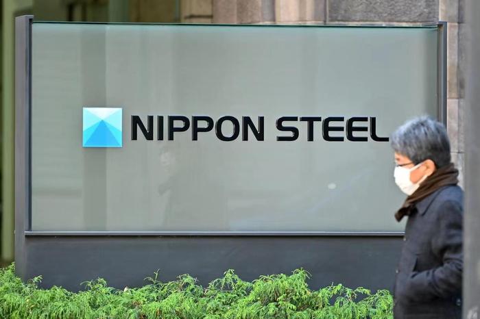▲别称须眉从位于日本东京的日本制铁公司总部公司标牌前走过。图/新华社