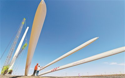 工程技术人员正在对即将安装的风力发电机叶片进行检测。（视觉中国供图）