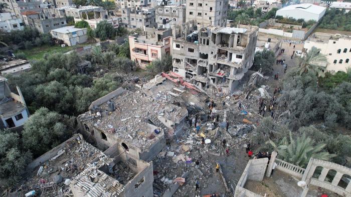 12月25日，加沙中部迈加齐难民营遭到以军空袭后，巴勒斯坦民众聚集在受损建筑附近 图源：IC photo