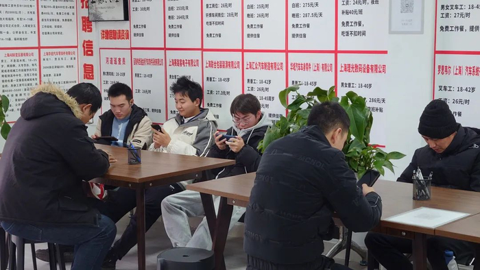 零工市场内等待咨询工作事宜的人